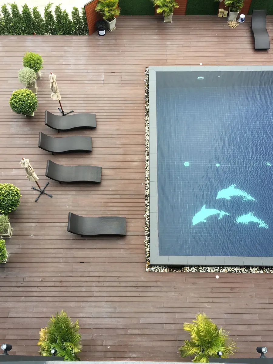 Overhead view of poolside decking and chairs. Representative stock photography.